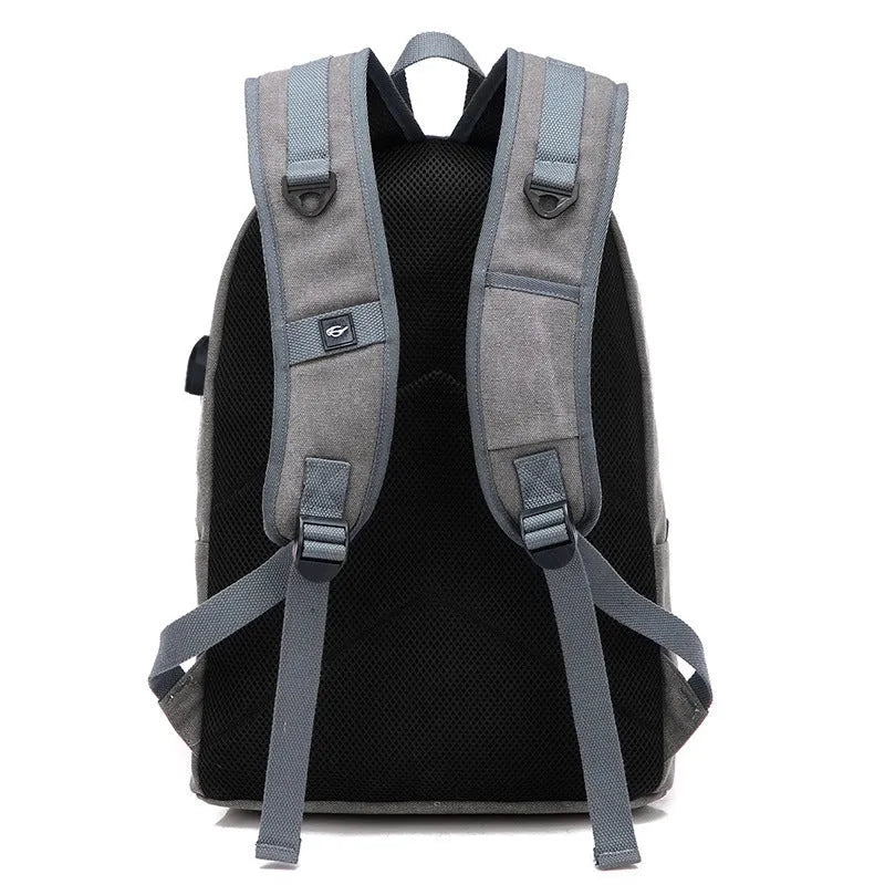 Canvas backpack in grey colour showing external USB port and multiple compartments.
