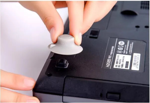 Grey durable plastic laptop cooling pads, two large and two small, on a desk.