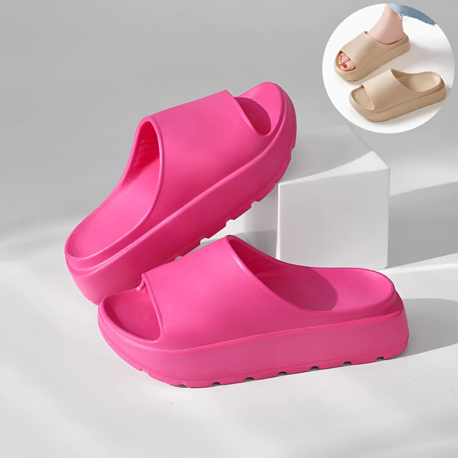 Women's beige open-toe beach slippers with a thick light-coloured sole on a wooden deck.