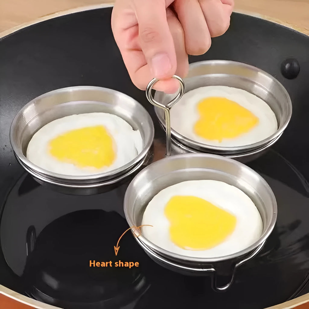Mini stainless steel egg steamer shown in heart-shaped and round designs on a kitchen counter.