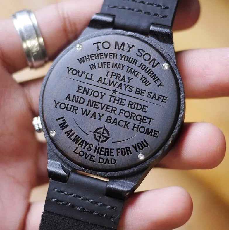 Custom wooden watch with ebony case, brown leather strap, and printed dial showing a logo