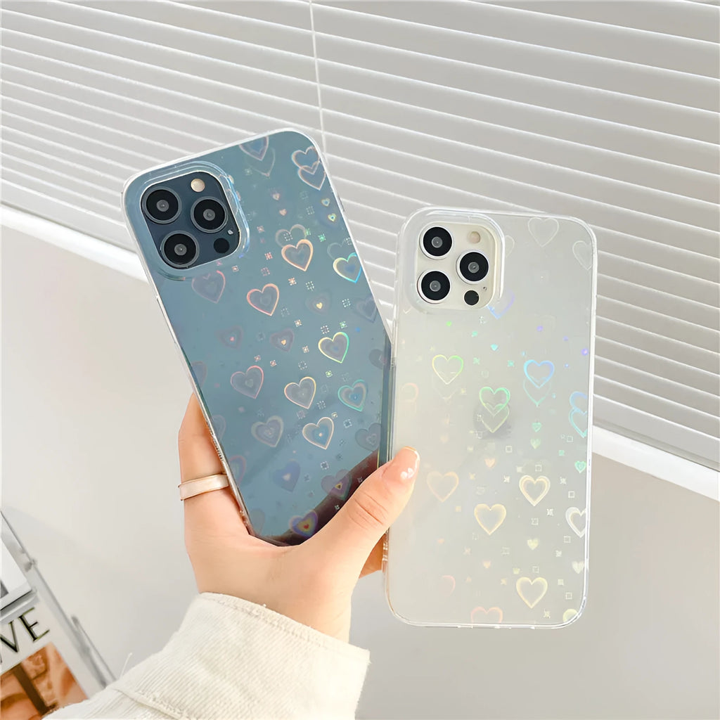 Transparent silicone iPhone case with laser-etched love heart design on a table.
