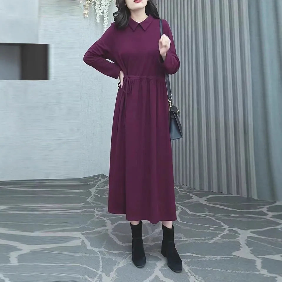 A purplish red plus size long sleeve dress with an ankle-length skirt on a mannequin.