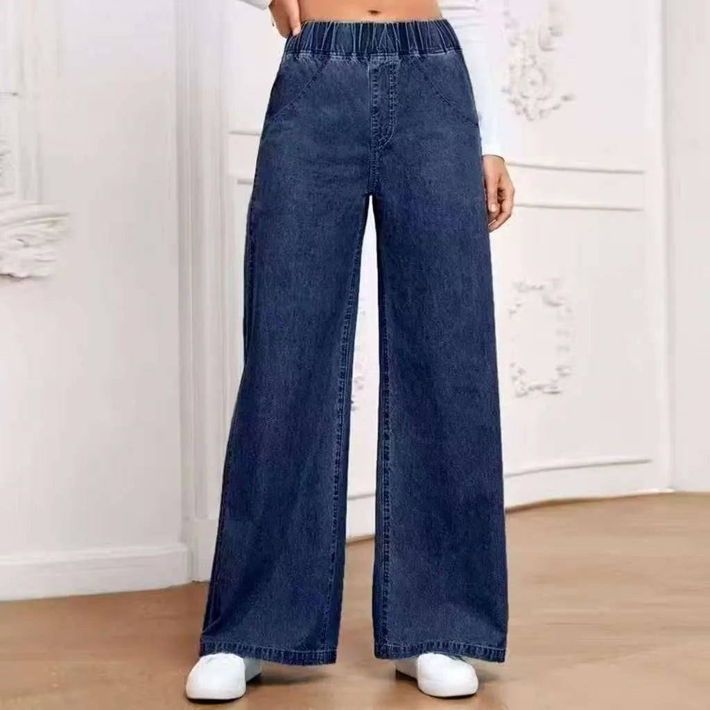 Light blue washed wide-leg straight-cut jeans on a hanger, showing mid-waist and zip fly detail.