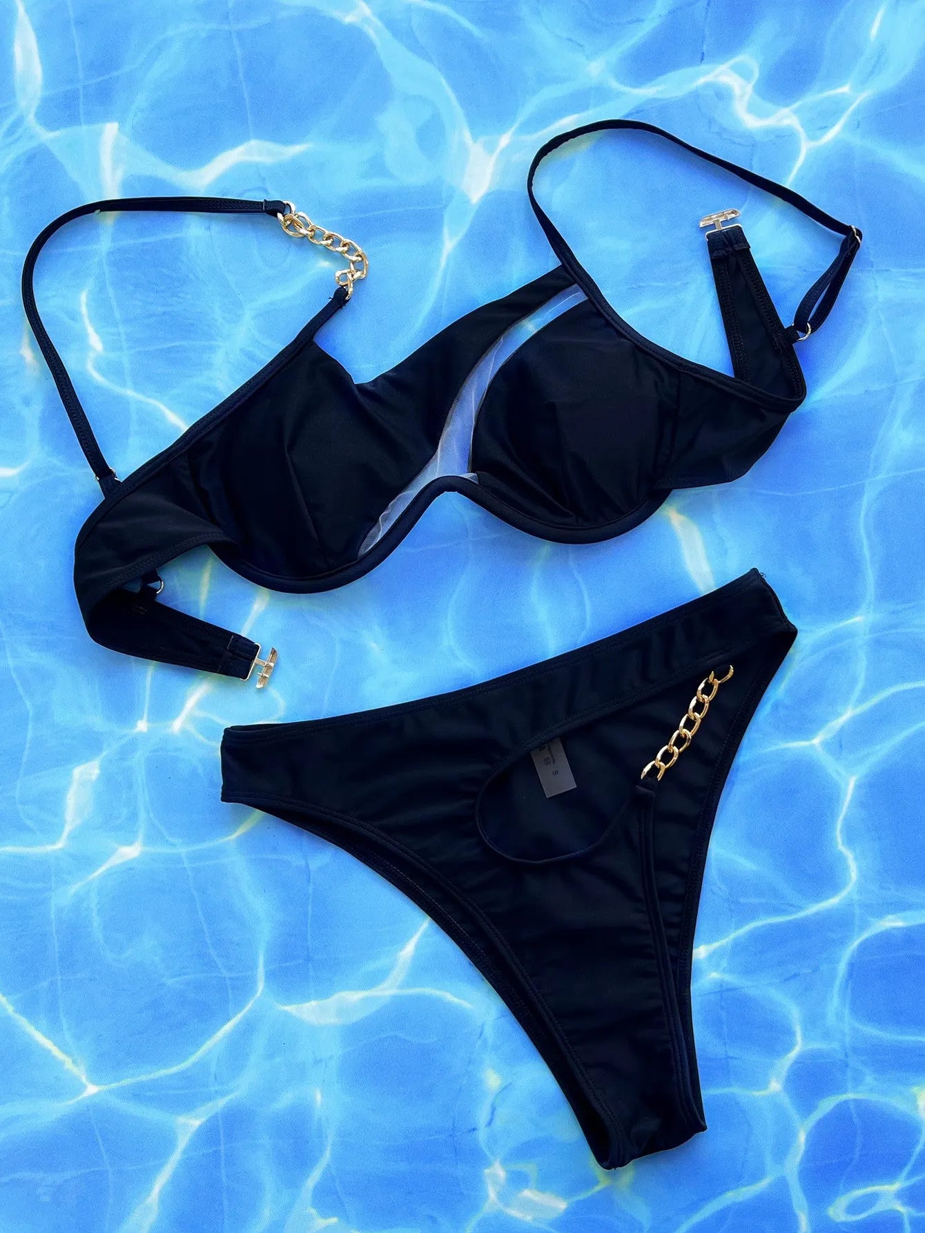 Black women's two-piece hollow split swimsuit set on a mannequin