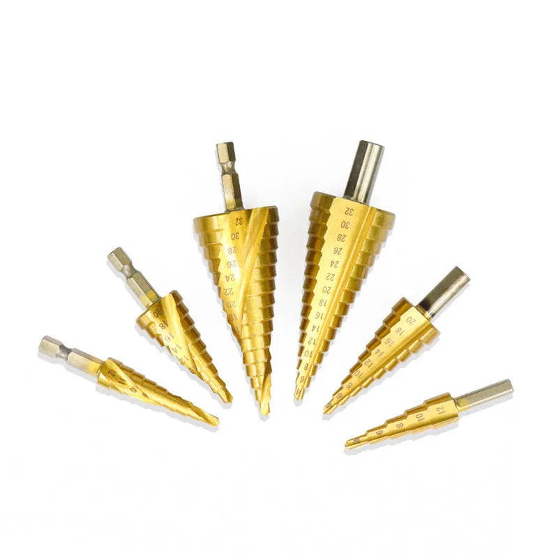 High-speed steel cone step drill bits and a centre punch laid out on a workbench.