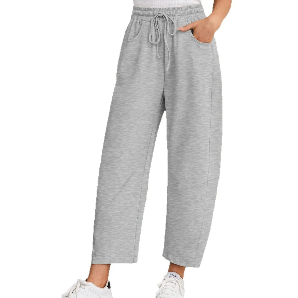Women's loose cropped sweatpants in apricot colour with drawstring waist and side pockets on a neutral background.
