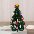 Green MDF Christmas tree ornament with laser-cut detail, 19x10.5cm, on a tree branch