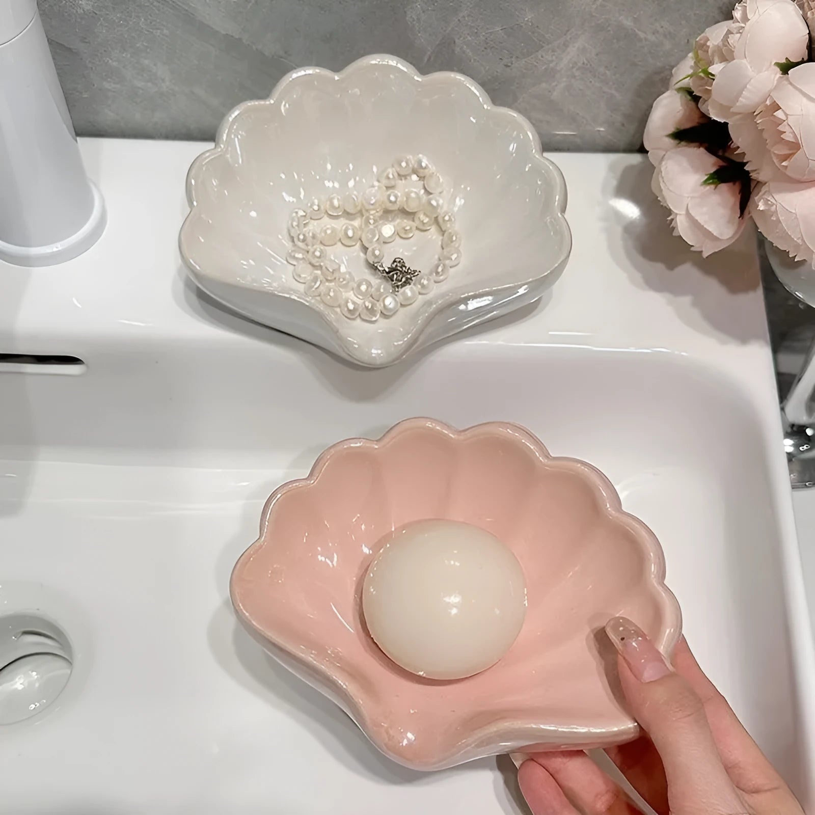 White plastic shell-shaped soap dish with drainage holes on a bathroom countertop