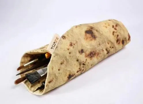 Fabric simulation burrito pencil case in clay oven rolls style, 22cm square, on a desk with pens inside