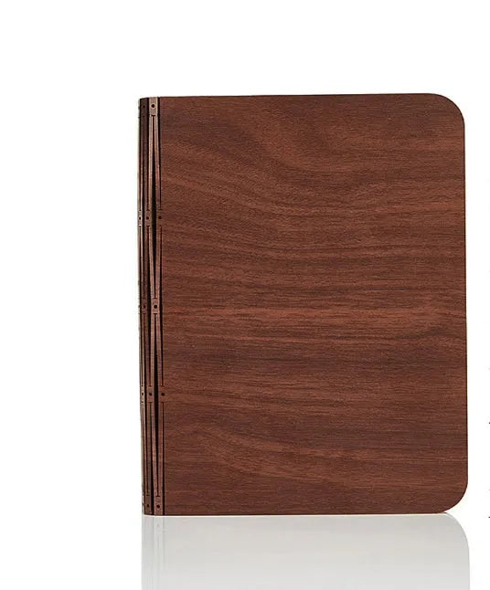 Solid wood book light with USB cable on a desk next to a book.