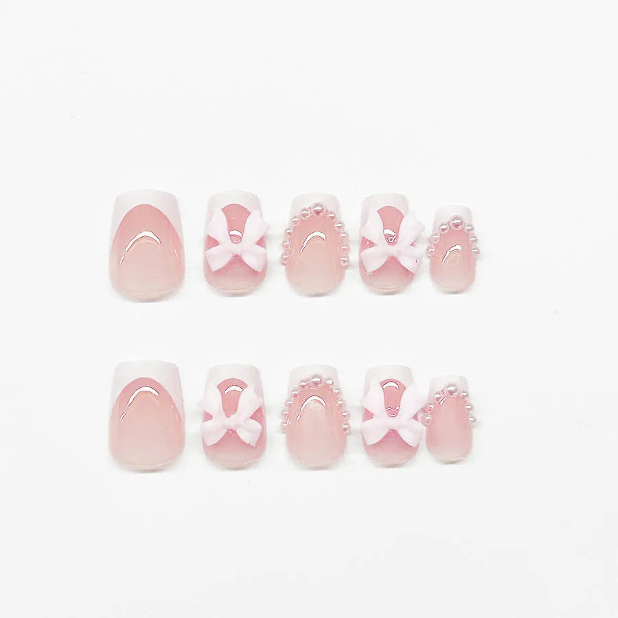 Pack of short white French manicure nail stickers with bow, tulip, and starry sky patterns.