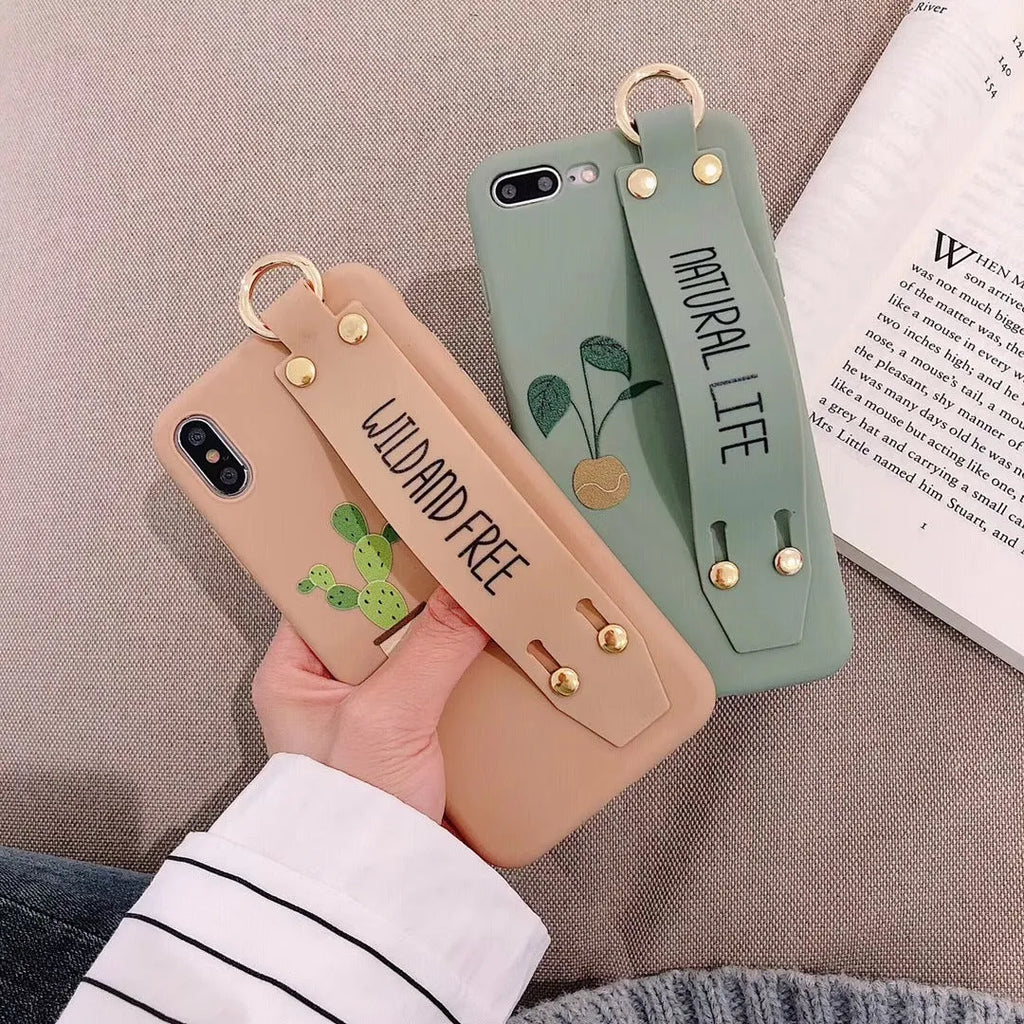 Green graffiti design wristband holder phone case for iPhone on a table.