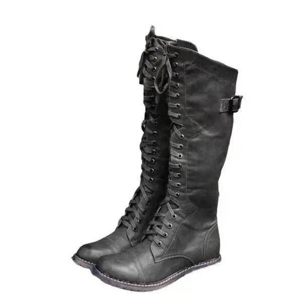 Women's black high-leg boots with a round toe and a low chunky rubber heel on a white background.
