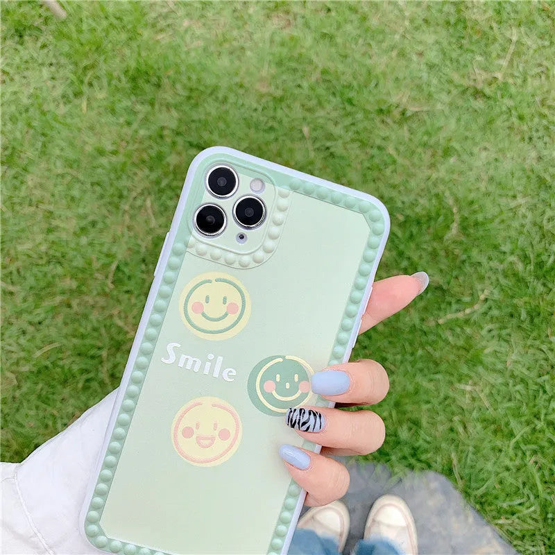 Green soft rubber TPU iPhone case with geometric pattern and smiley face polka dot frame design.