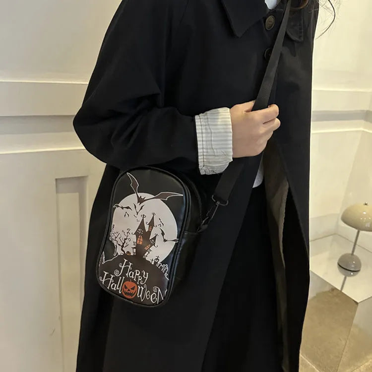 Black mini crossbody bag with Halloween graffiti print of cartoon pumpkins and bats.