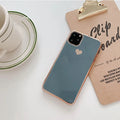 Simple solid colour TPU back cover case for iPhone on a table, shown in Blue.