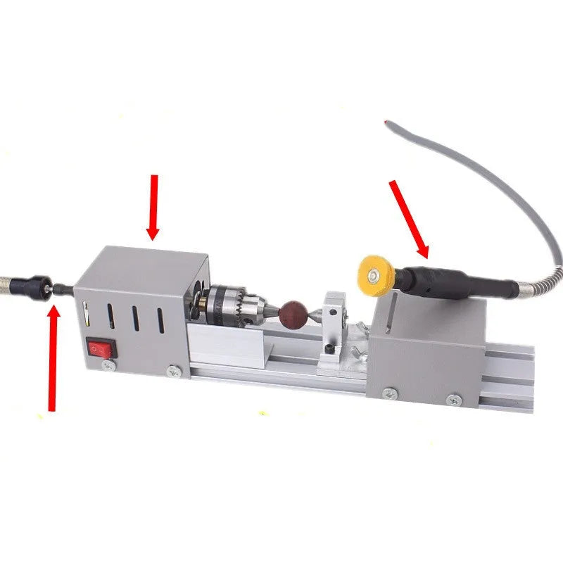 Silver metal mini woodworking lathe on a bench with carving knives and accessories.