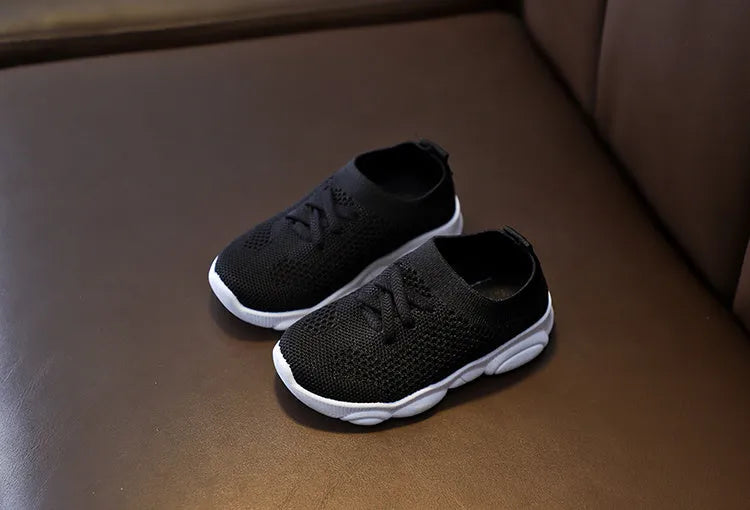 Children's lazy slip-on shoes in white, black, pink, or grey with fabric upper and rubber sole.