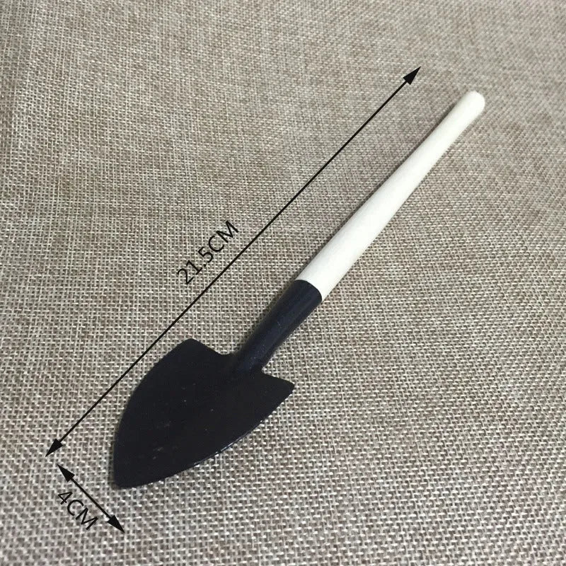 Succulent gardening tool set showing drip kettle, tweezers, mini shovel, rake, and other small plant care tools on a table.