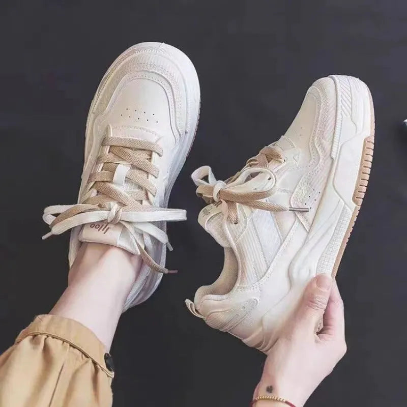 Women's pink low-top sneaker with imitation leather upper and rubber sole on a plain background.