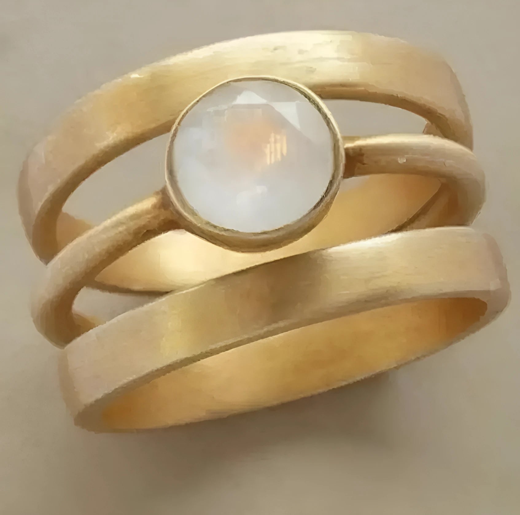 Gold geometric titanium steel ring with a small white chalcedony stone set in a hollow design.