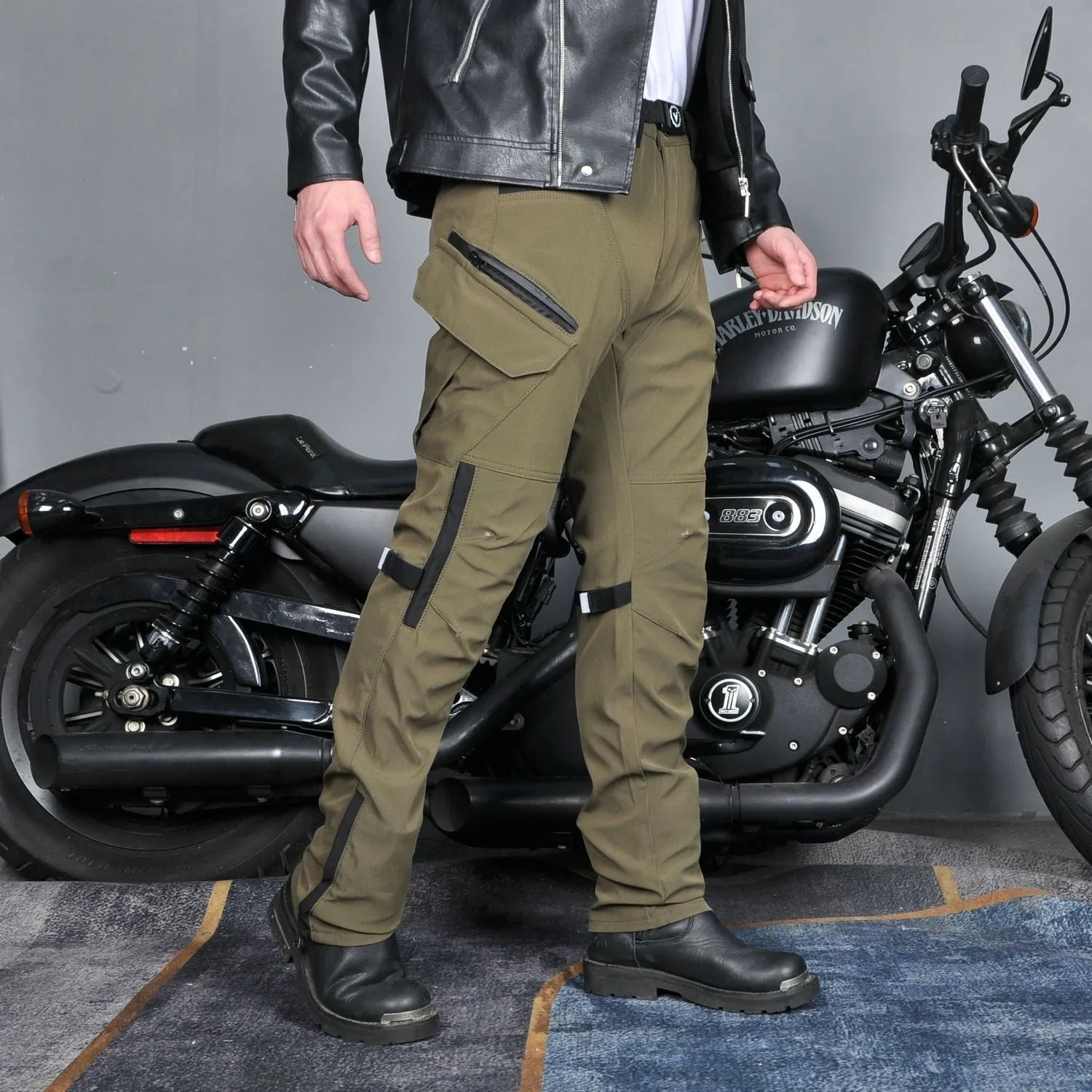 Man wearing green waterproof motorcycle trousers with belt and protective gear for cycling.