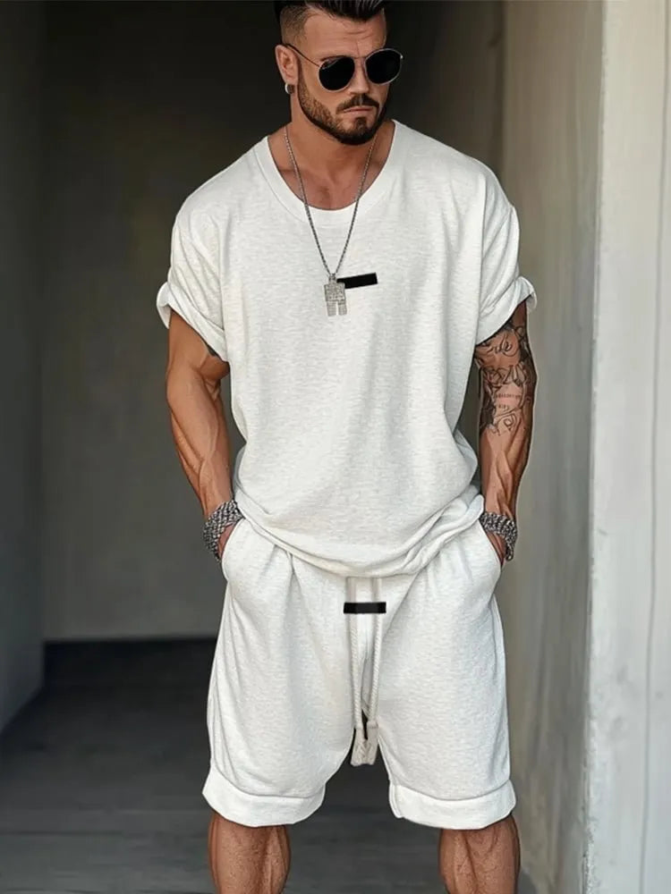 Men's hip hop style grey T-shirt with letter printing and matching shorts on a hanger.