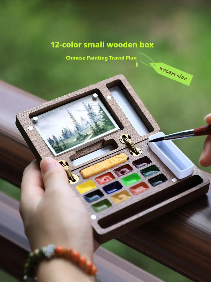 Mini walnut wood watercolour paint box set open showing internal brush and paint compartments.