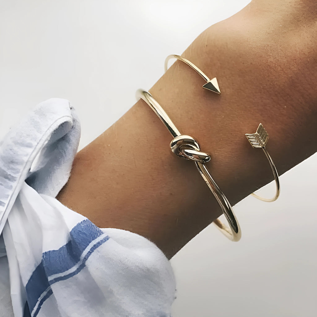 Gold women's vintage bracelet with knotted cuff design and central arrow motif