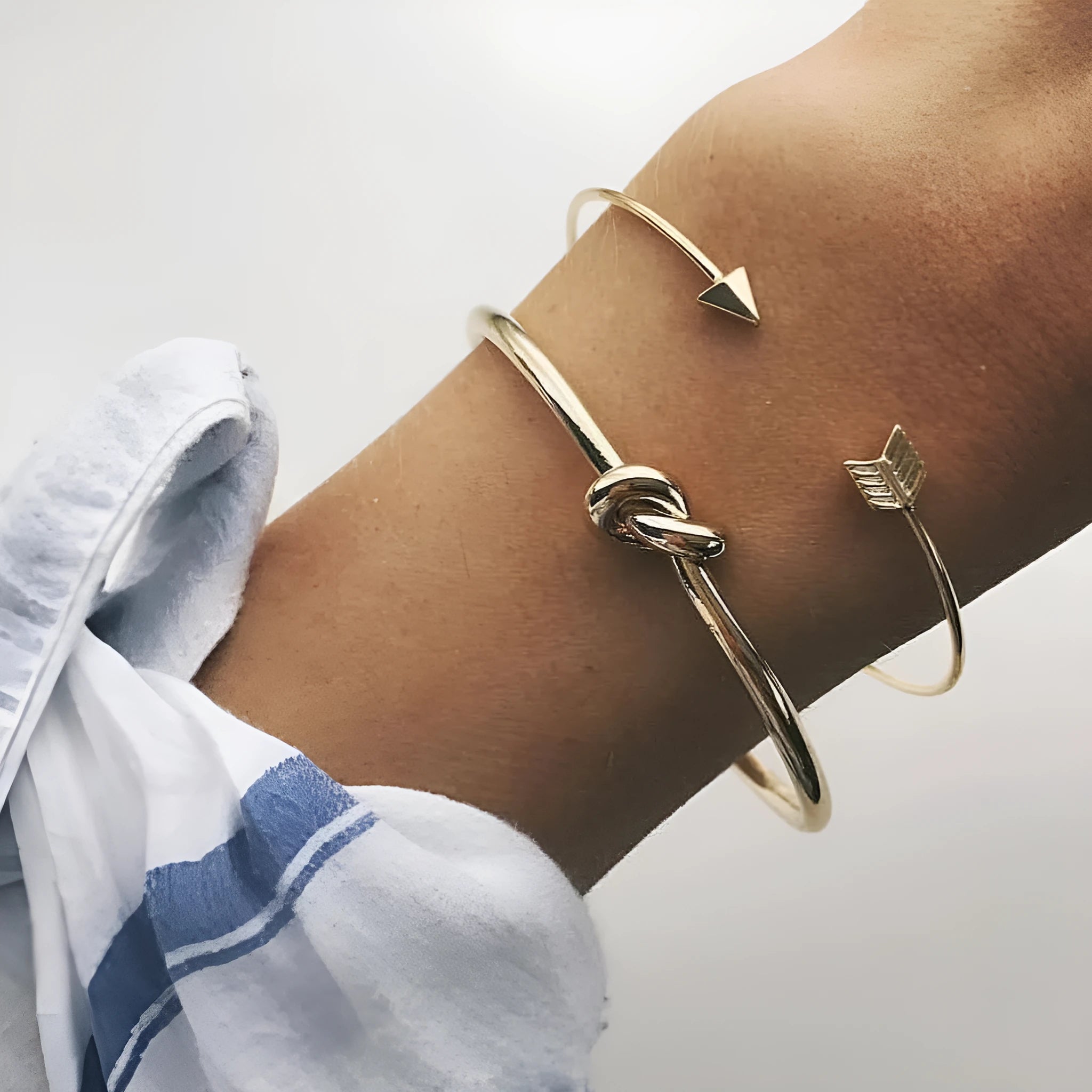 Gold women's vintage bracelet with knotted cuff design and central arrow motif