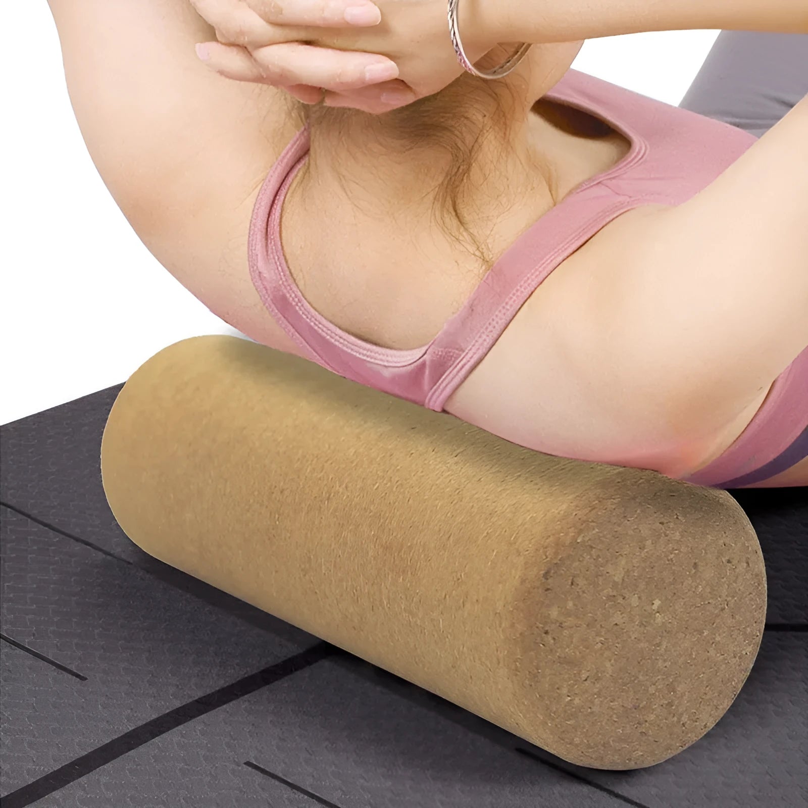 Natural cork yoga wand cylinder 30x10cm massage roller on a yoga mat with green background