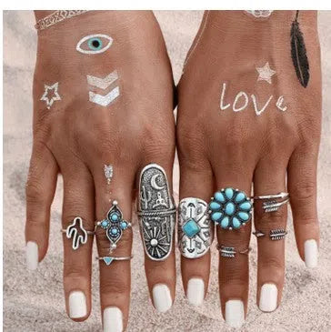 Boho vintage ring set in ancient silver with flower engraving and gemstone inlay laid out on a flat surface