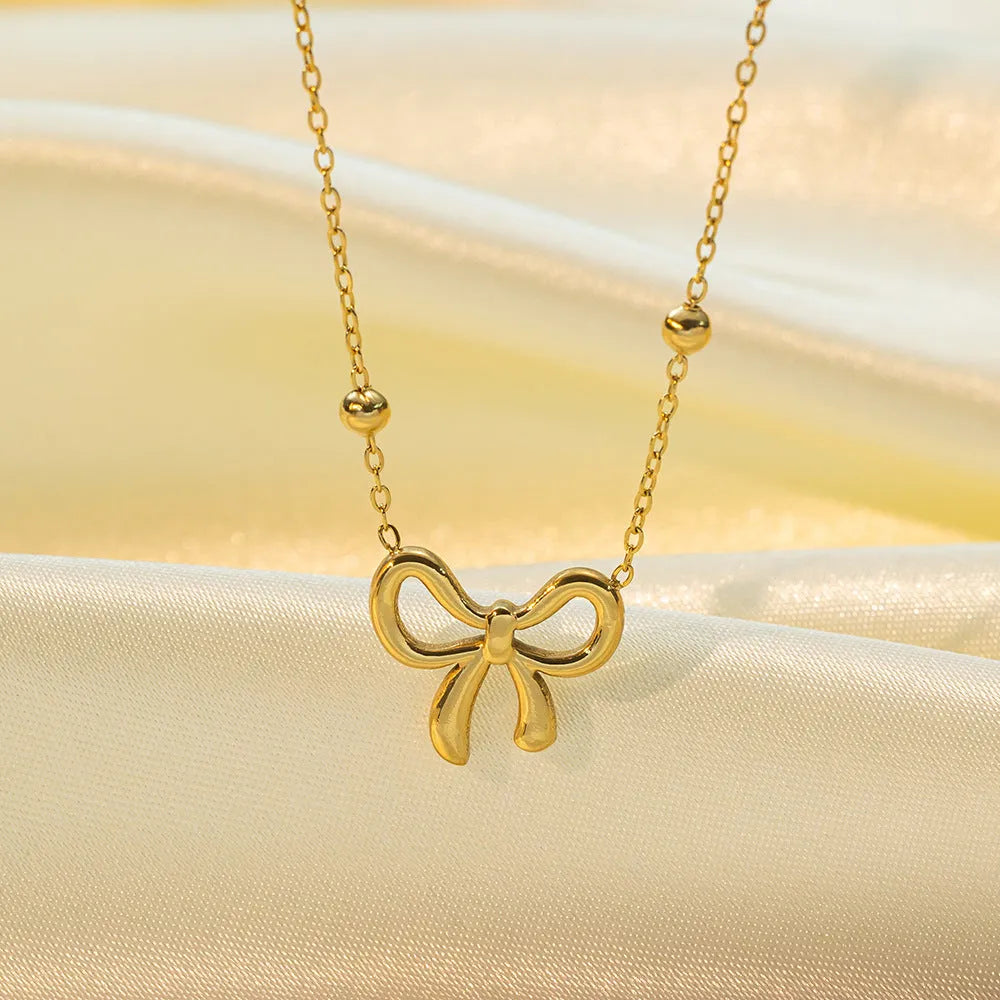 Gold titanium steel bow necklace for women with adjustable length and cross chain design