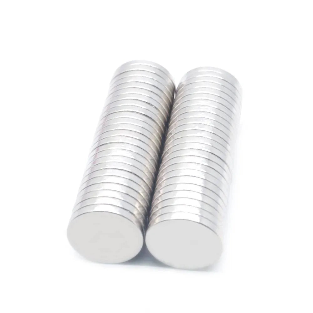 Silver neodymium magnet disc 14x2mm on plain background