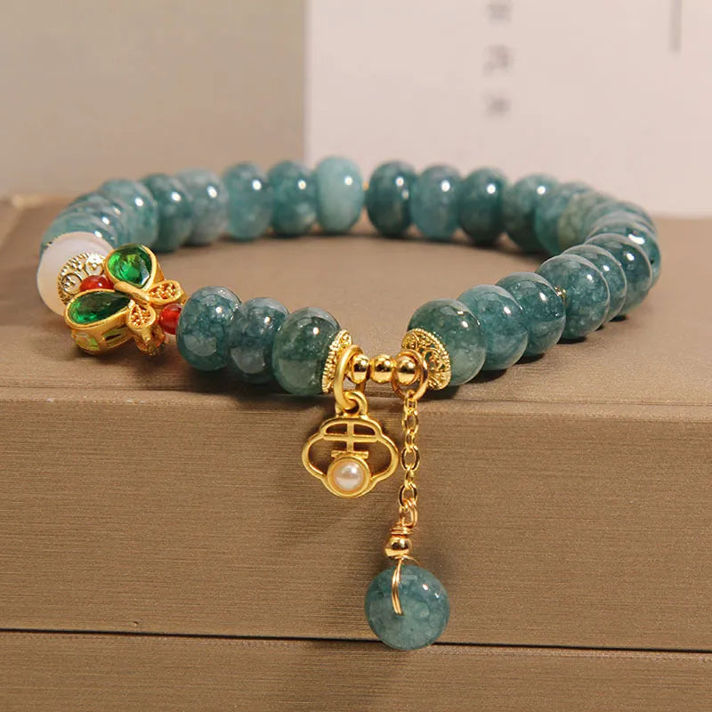 Women's blue water jade and white agate abacus bead bracelet with rhinestones and a butterfly charm on an alloy chain.