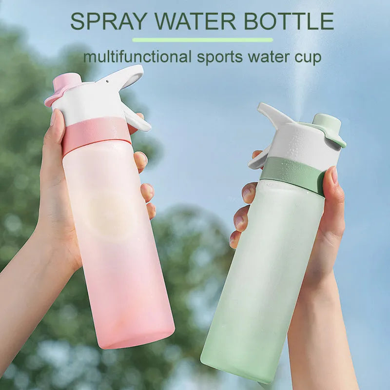 Large pink plastic spray water bottle with a handle strap and leakproof lid on a gym bag.