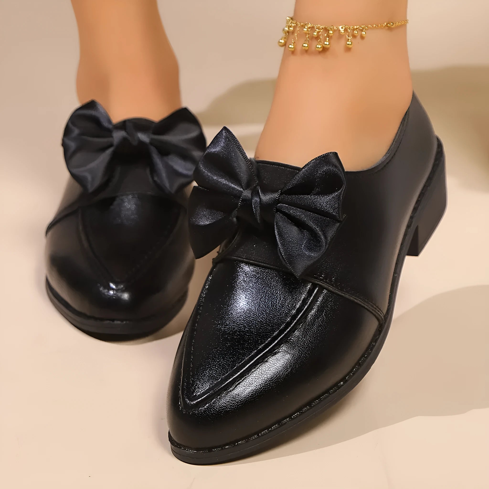 Women's beige PU leather slip-on shoes with a large bow decoration and rubber sole.