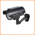 Black plastic fake security camera with gun-style design and solar simulation LED light