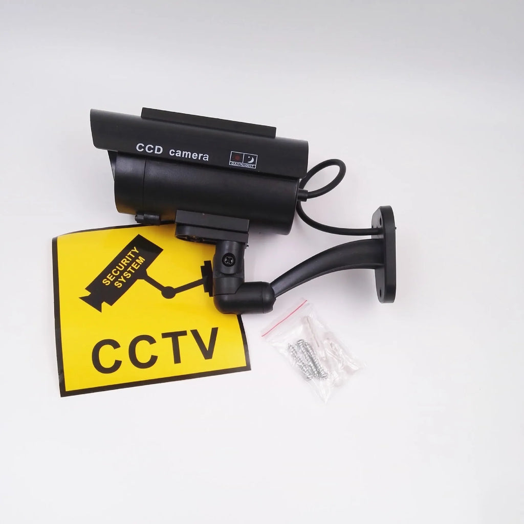 Black plastic fake security camera with gun-style design and solar simulation LED light
