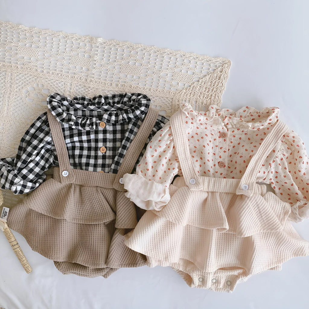 Baby girl wearing a cotton romper with a pleated lotus leaf sling and triangle climb design in apricot colour.