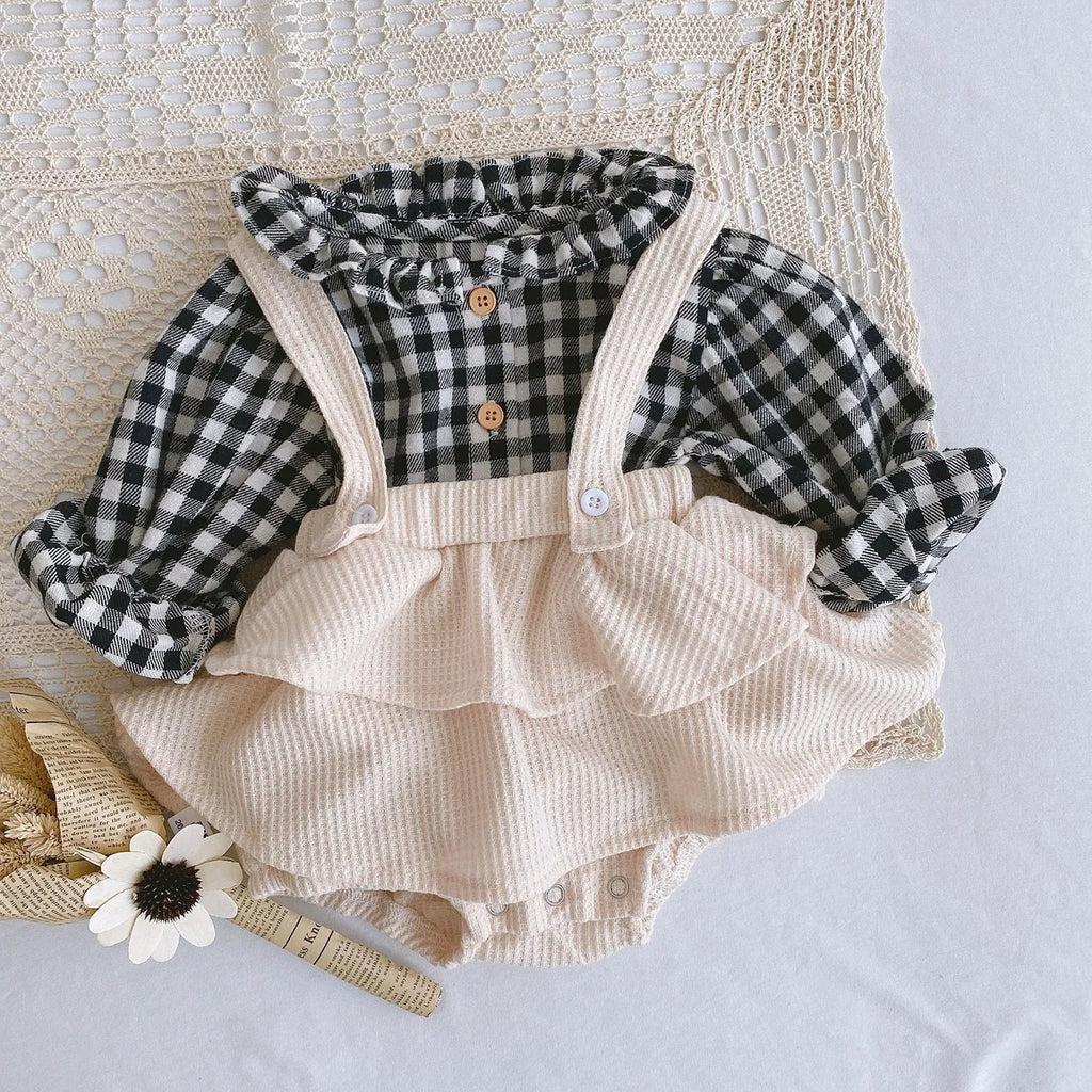 Baby girl wearing a cotton romper with a pleated lotus leaf sling and triangle climb design in apricot colour.