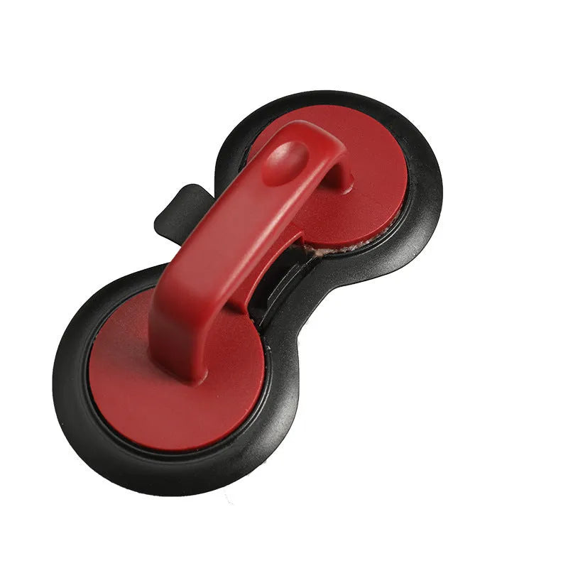 Black and red round burger press mould with oil paper liners on a kitchen counter.