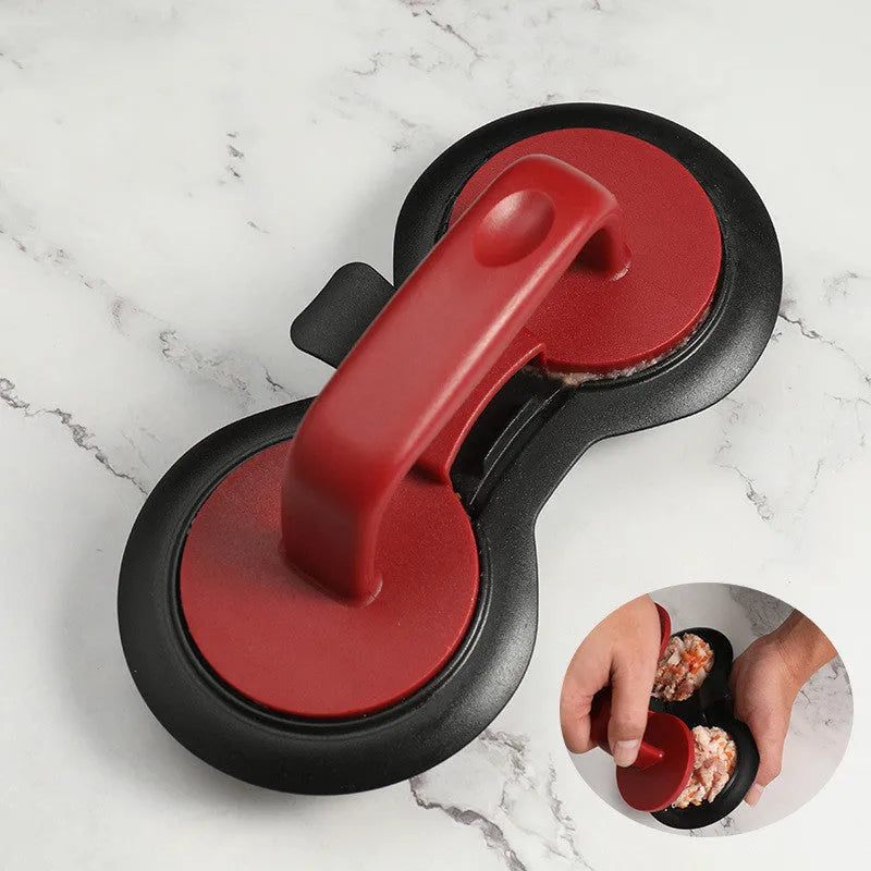 Black and red round burger press mould with oil paper liners on a kitchen counter.