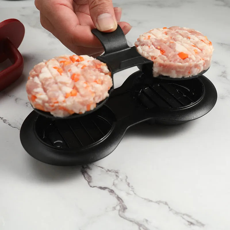 Black and red round burger press mould with oil paper liners on a kitchen counter.