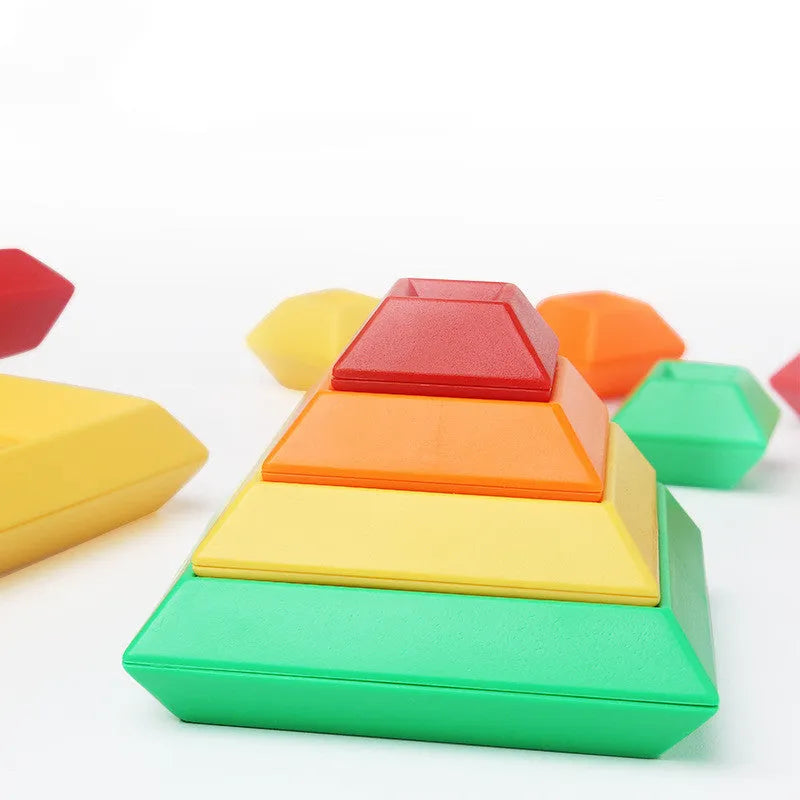 Rainbow-coloured wooden jenga-style building blocks forming three towers for children's educational play