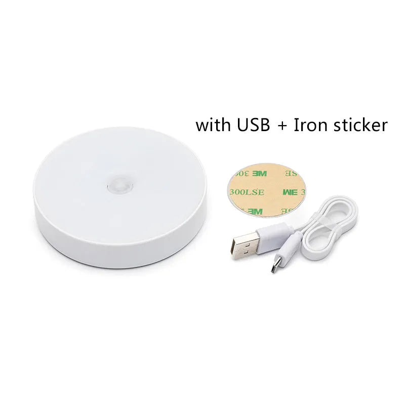 Small white USB rechargeable motion sensor LED night light with adhesive tape for mounting.