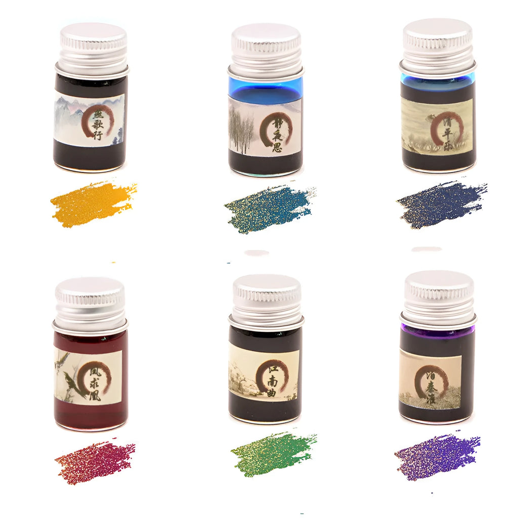 Set of six small glass bottles of gold powder dipping pen ink in different colours.