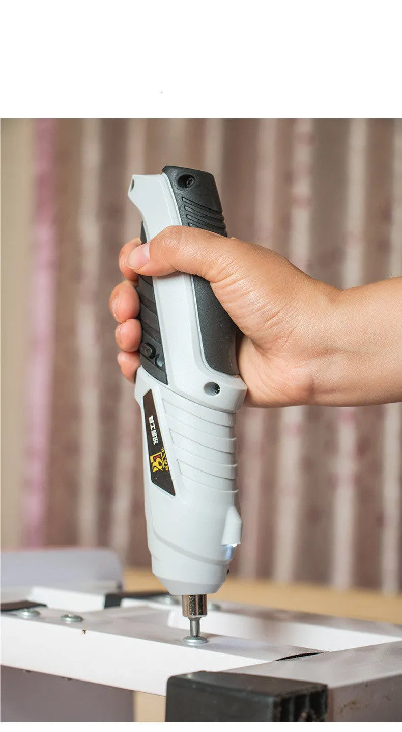 Black rechargeable pistol grip screwdriver with USB cable and set of driver bits on a grey background