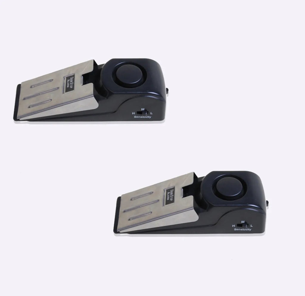 Black portable door stop alarm with wedge shape and stainless steel sensor cover.